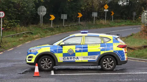 PA Media A garda patrol card blocking a road. There are traffic cones.