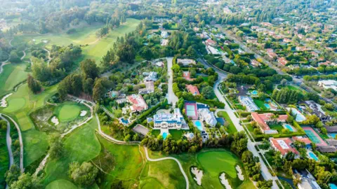 Getty Images Aerial view of Bel-Air neighbourhood, showing big houses, lots of swimming pools, and a big golf course.