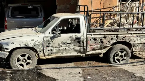 Reuters A vehicle sits abandoned, its frame peppered with holes from gunfire