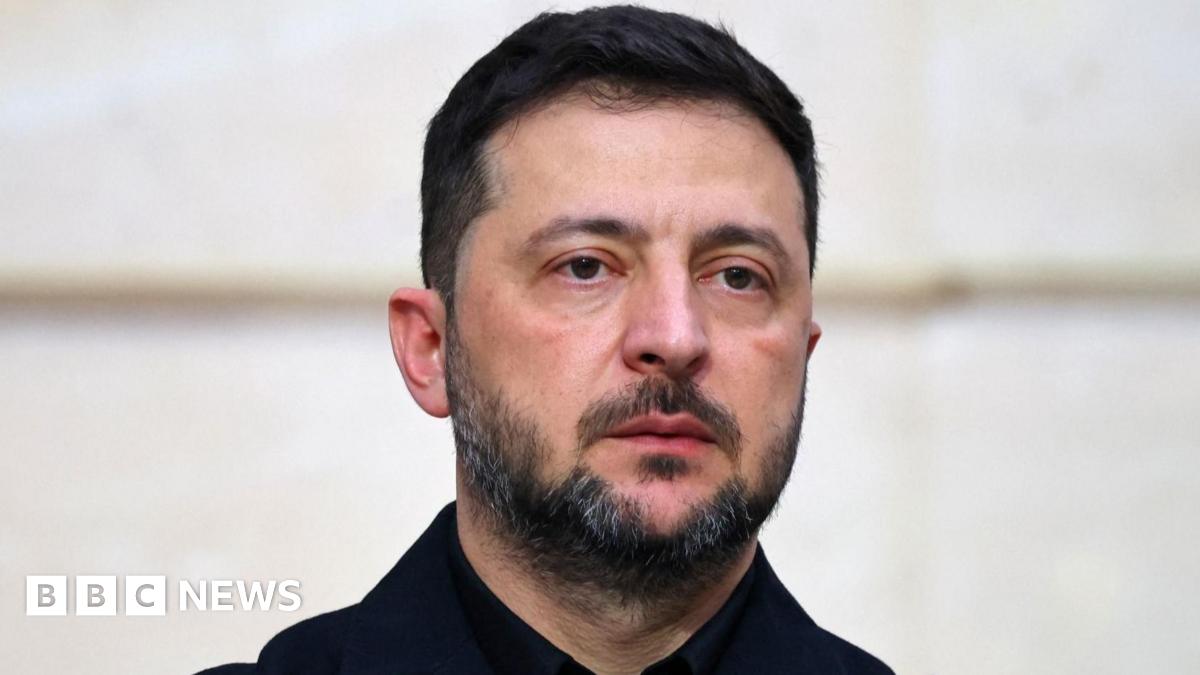 Ukrainian President Volodymyr Zelensky looks off into the distance. He's wearing a black shirt.