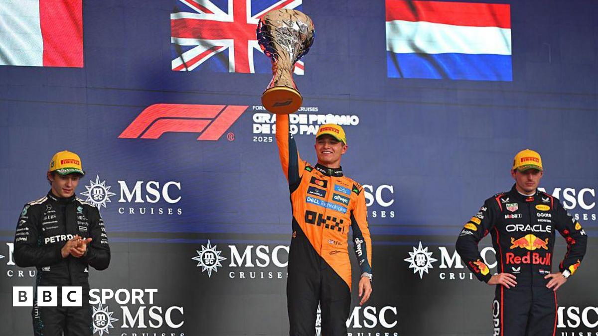 Lando Norris lifts his winner's trophy on the podium in Sao Paulo