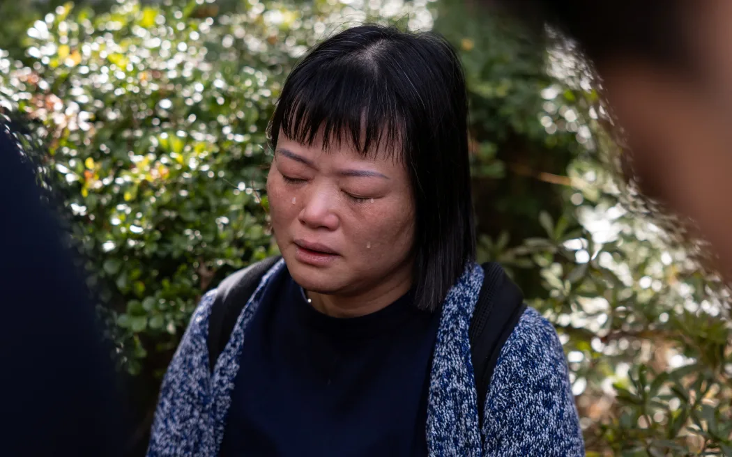 A resident reacts as she speaks to the media in the aftermath of a major fire that swept through several apartment blocks at the Wang Fuk Court residential estate in Hong Kong's Tai Po district on 28 November, 2025.