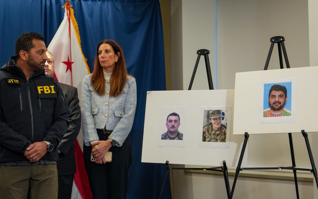 FBI Director Kash Patel (L) looks at photos of the two West Virginia National Guard soldiers shot in Washington, DC, along with the suspect in the shooting on 27 November, 2025.