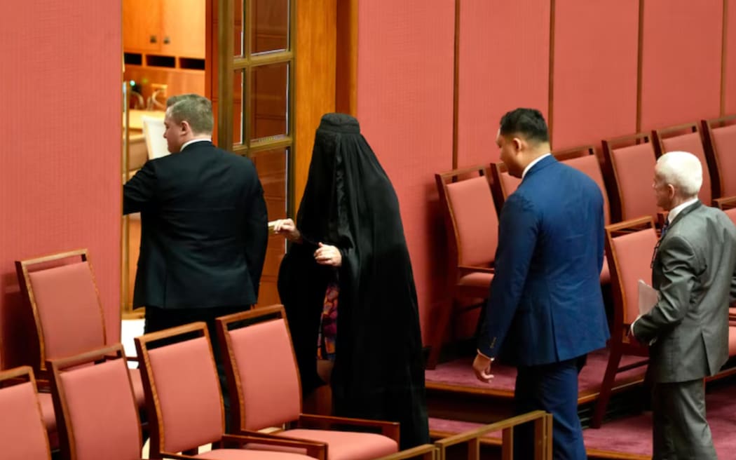 Pauline Hanson leaves the Senate, wearing a burka, after proceedings were suspended.
