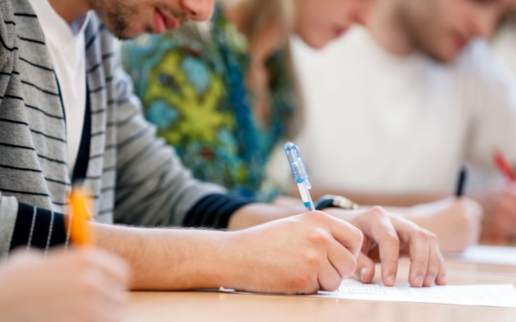 21790139 - writing hands of students at course