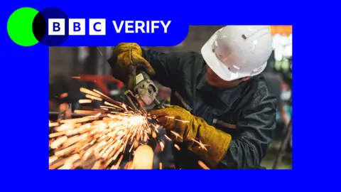 Getty Images A picture of a person wearing a white hard hat and using a machine tool with sparks flying out