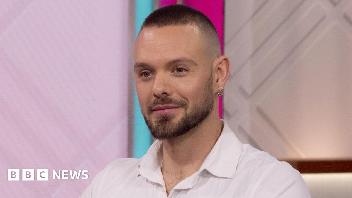 John Whaite pictured on ITV's Lorraine in August 2023, wearing a white shirt and looking straight ahead