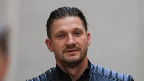 Collins Photos Dublin Karolis Peckauskas has short black hair and beard. And is wearing a black jacket.