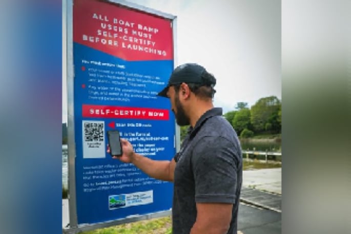 Bay of Plenty Regional Council biosecurity officer Te Wakaunua Te Kurapa demonstrates how to scan for self-certification at Lake Ōkataina. 