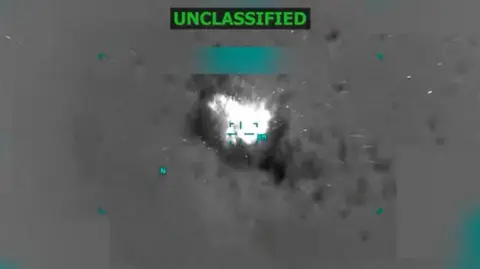 Reuters Black and while taken from military footage of a boat exploding after being hit in a US strike. 