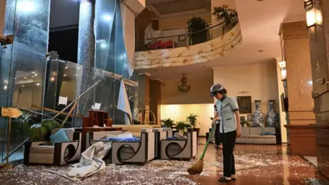 AFP via Getty Images Image shows a person sweeping up debris in a hotel in Vietnam 