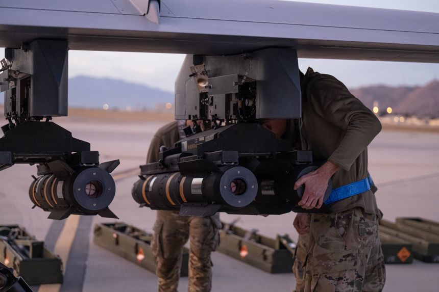 US Air National Guard maintenance personnel begin loading AGM-114 Hellfire missiles on the hot cargo pad at March Air Reserve Base in California, on December 10, 2023.