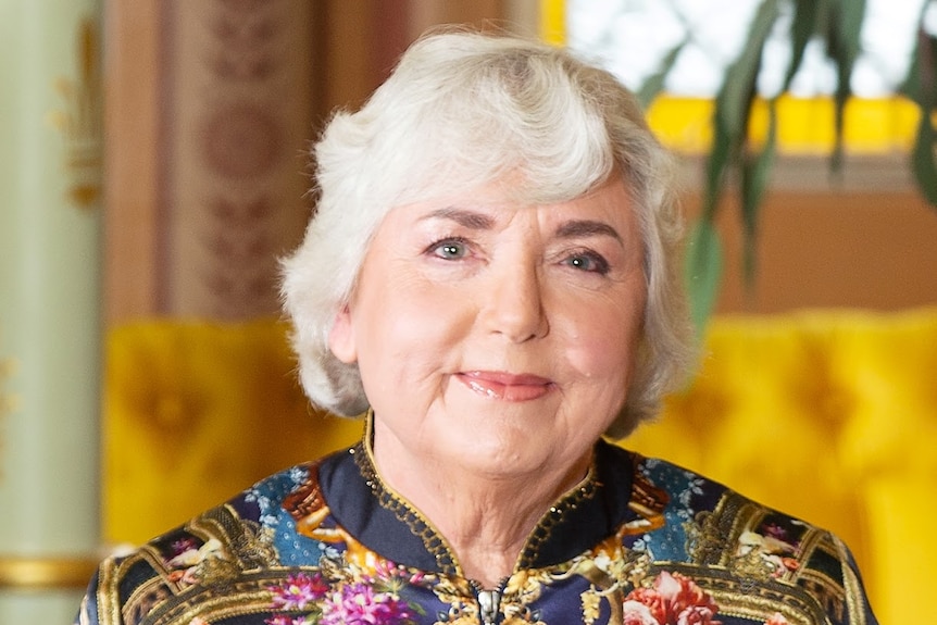 a middle-aged lady sits in a chair