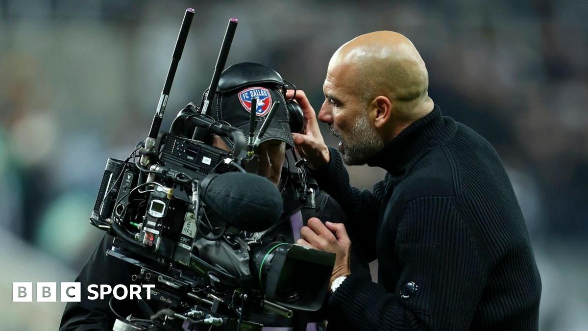 Pep Guardiola removes a cameraman's headphones while speaking to him after Manchester City's defeat at Newcastle