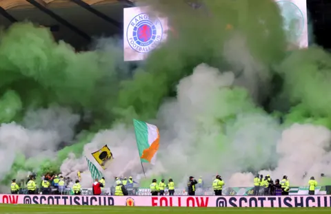 PA Media Green and white smoke flares are set off during the Scottish Cup semi-final match at Hampden Park, Glasgow in 2023