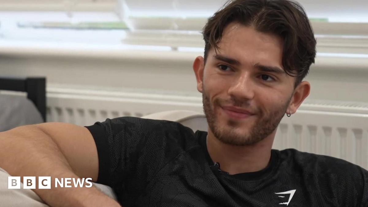 Oliver Archer sat on a sofa in a black sports t-shirt.