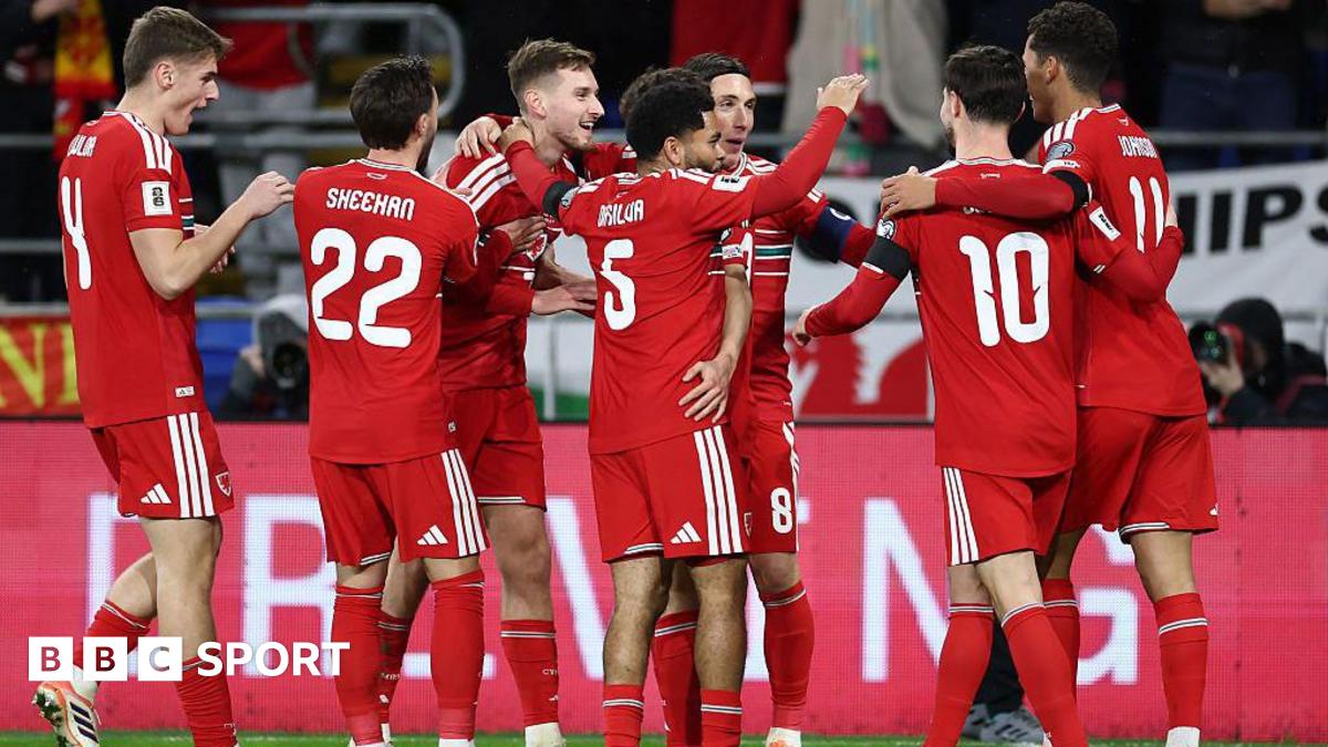 Wales players in red shirts celebrate a goal