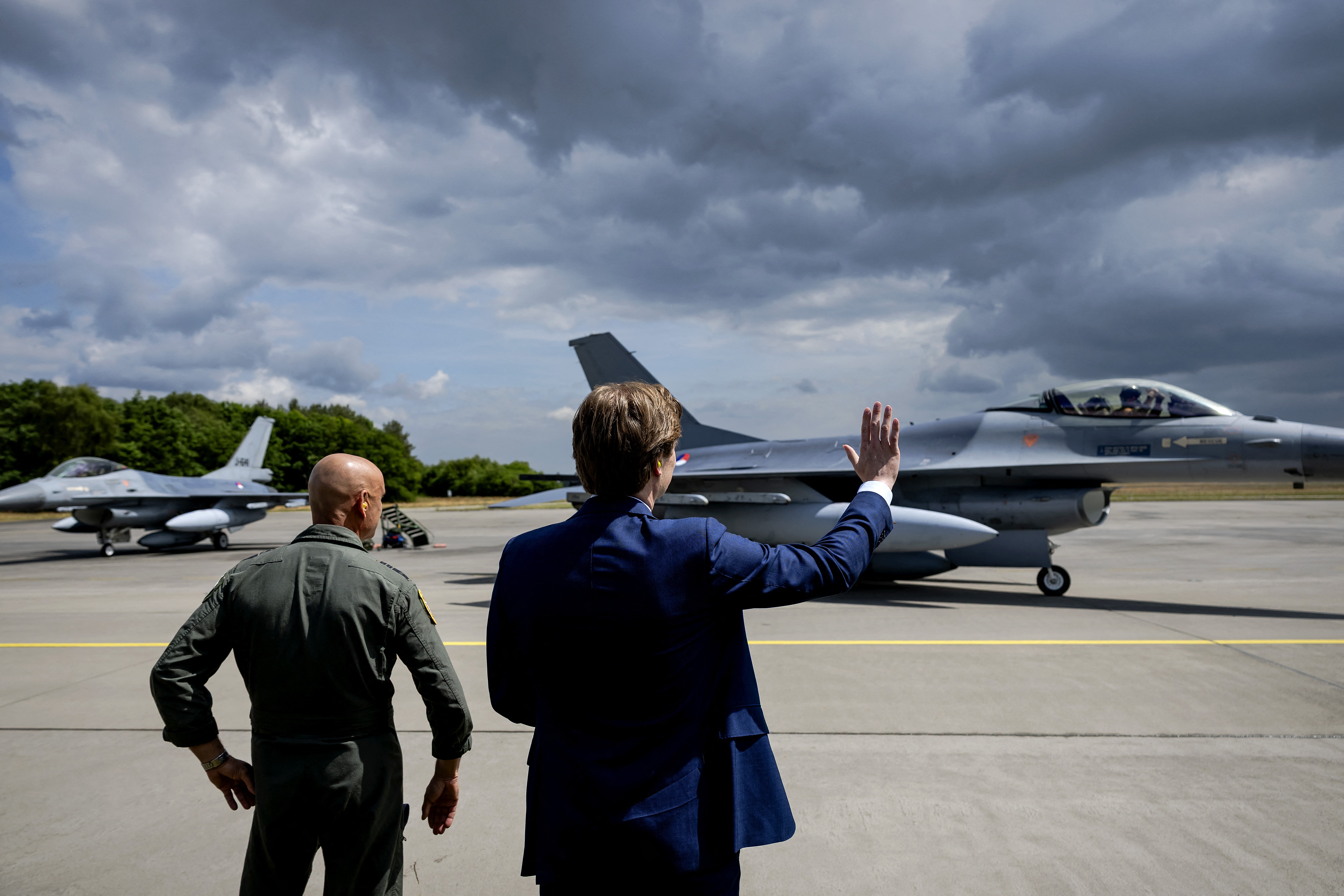 Dutch Defense Minister Ruben Brekelmans (R) waves goodbye to the last two F16 fighter jets to be sent to Ukraine as they leave Volkel Air Base, The Netherlands, on May 26, 2025. (Photo by Robin van Lonkhuijsen / ANP / AFP) / Netherlands OUT (Photo by ROBIN VAN LONKHUIJSEN/ANP/AFP via Getty Images)