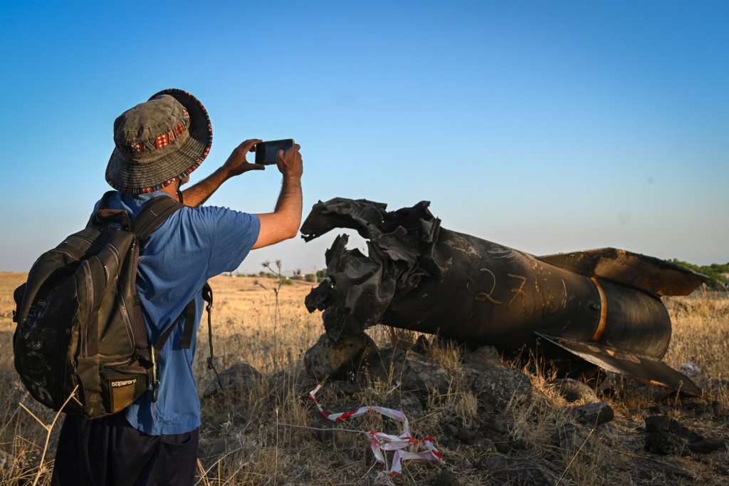 Members of the Israeli security forces check the apparent remains of an Iranian ballistic missile lying on the ground on the outskirts of Qatzrin, Golan Heights, Israel, on Monday, June 23, 2025. (Photo by Michael Giladi / Middle East Images via AFP) (Photo by MICHAEL GILADI/Middle East Images/AFP via Getty Images)