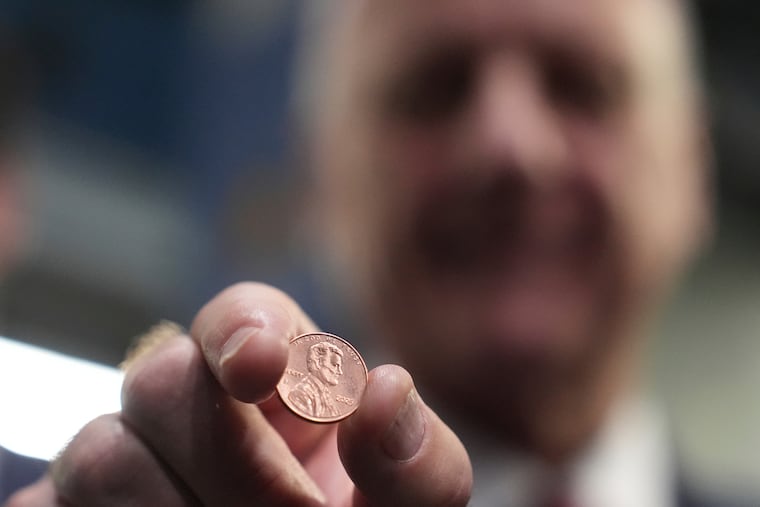 U.S. Treasurer Brandon Beach holds one of the last pennies pressed at the U.S. Mint in Philadelphia.