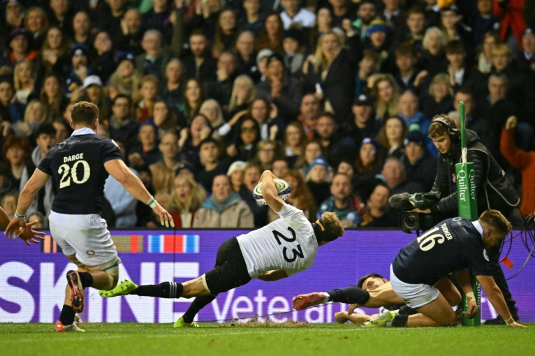 Damian McKenzie scores a try against Scotland