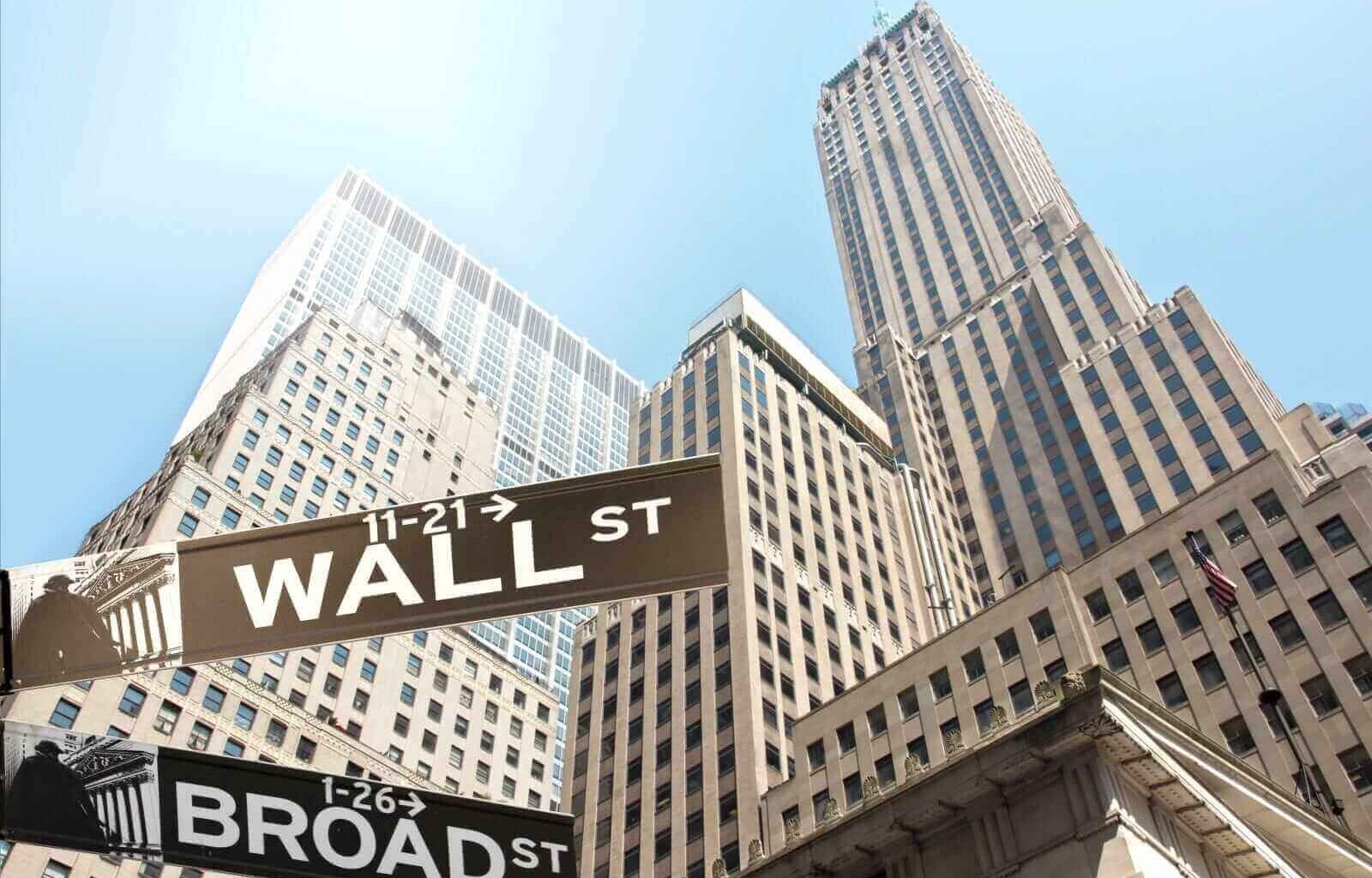 Road sign of New York Wall street corner Broad street by Mezzotint via Shutterstock
