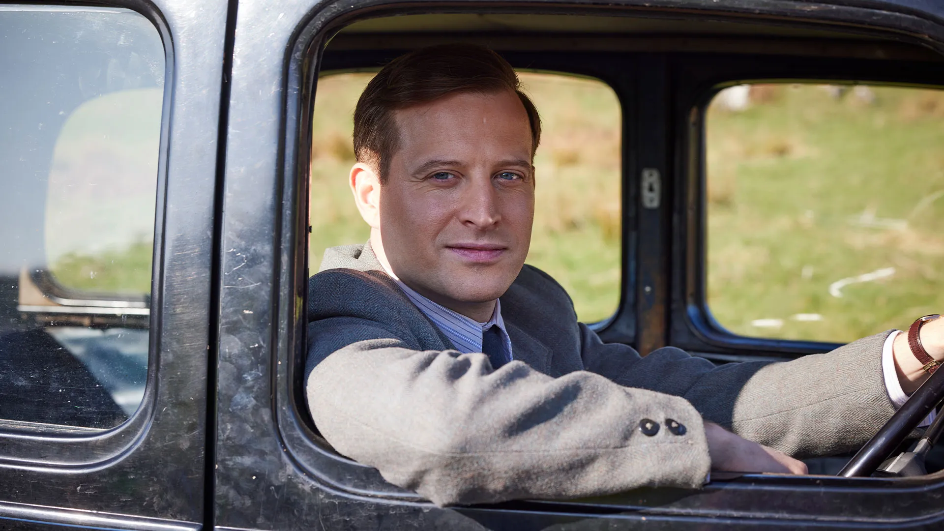 Nicholas Ralph as James Herriot gazing out a car window in All Creatures Great and Small