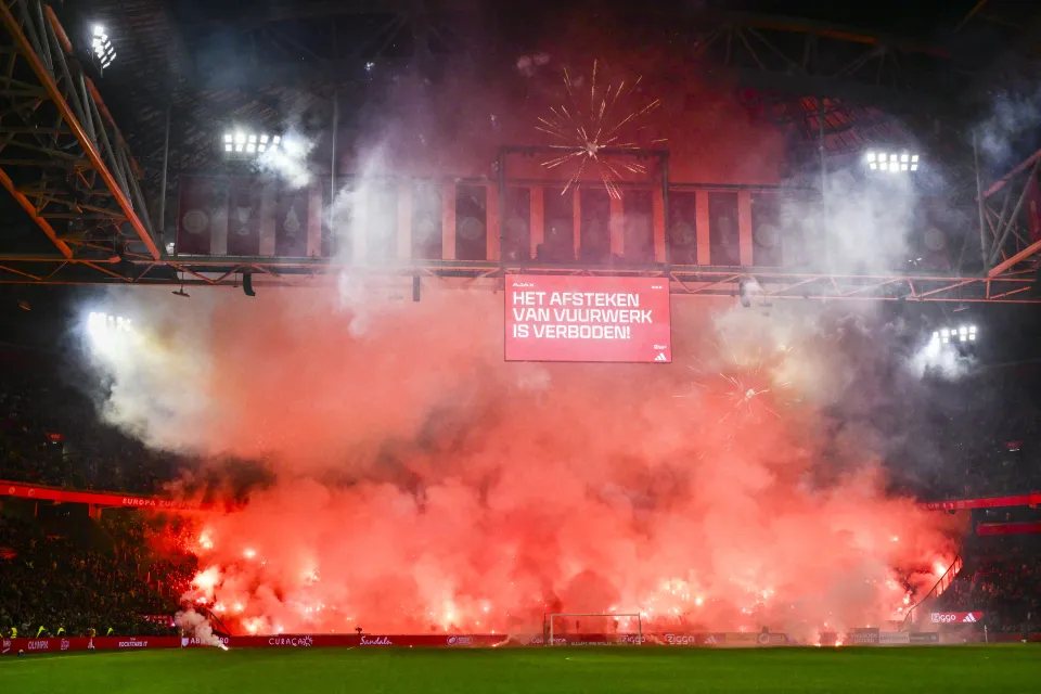 Ajax’s supporters light smoke bombs in memory of supporter during the Dutch Eredivisie football match between Ajax Amsterdam and FC Groningen at the Johan Cruijff ArenA in Amsterdam on November 30, 2025. 