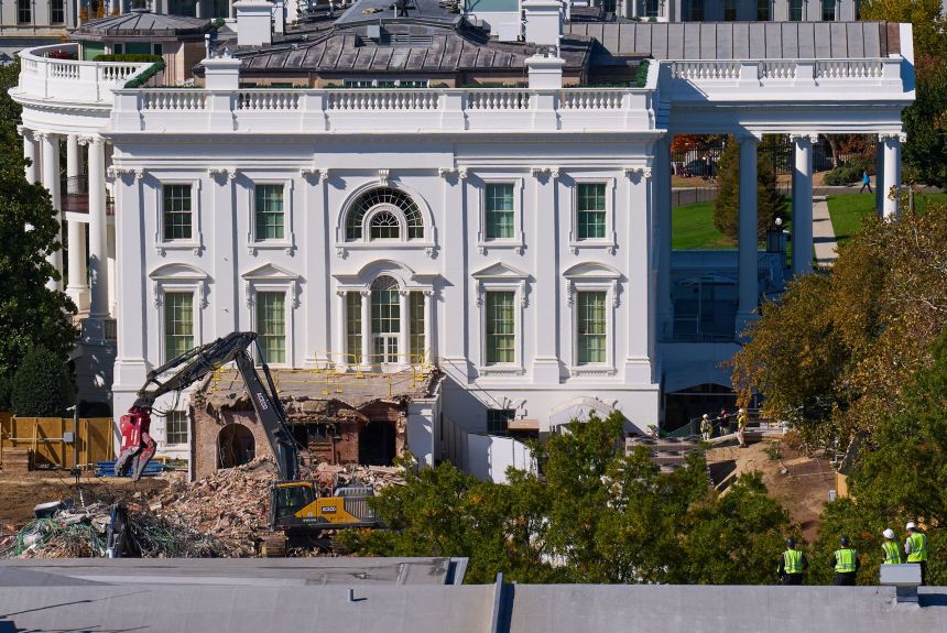 Construction workers, bottom right, atop the US Treasury, watch as work continues on a largely demolished part of the East Wing of the White House in Washington, DC, on October 23.