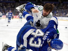 Conor Garland (8) knocks down Tampa Bay Lightning defenceman Darren Raddysh (43) as they fight during the first period