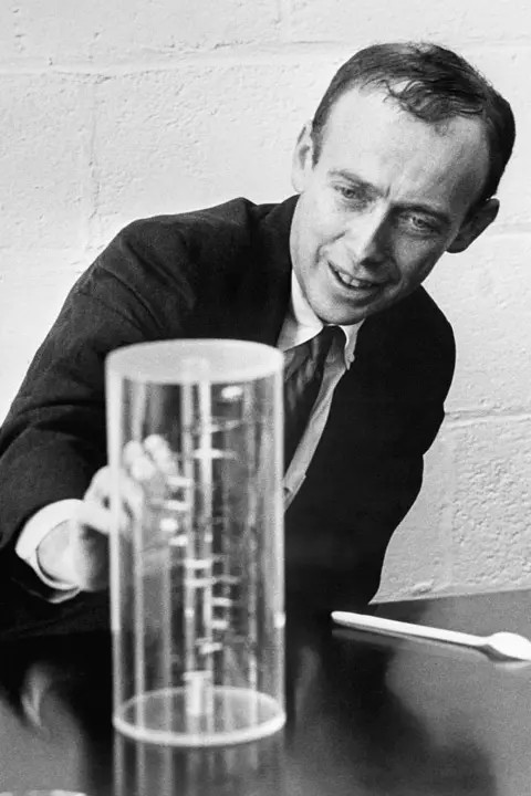 Getty Images James Watson studying a model of DNA's double-helix structure