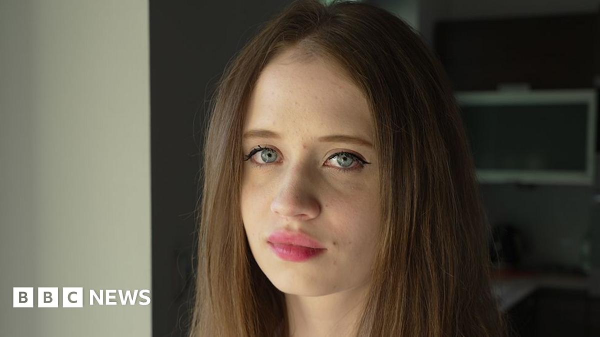 A portrait of Viktoria, a young woman with long, brown hair and blue eyes, pictured close-up and facing the camera