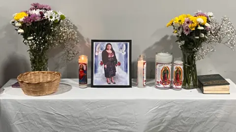 CBS A photo of Maria Florinda Rios Perez is in a frame on a table with candles and flowers