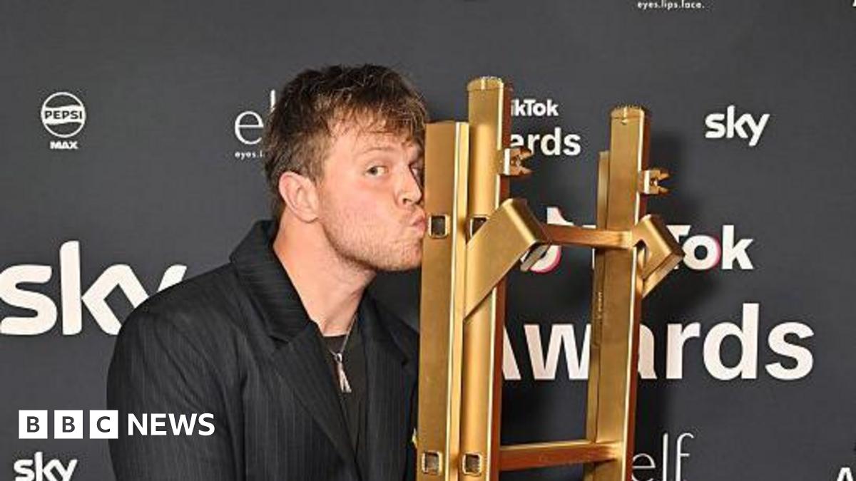 Max Klymenko kissing a golden ladder