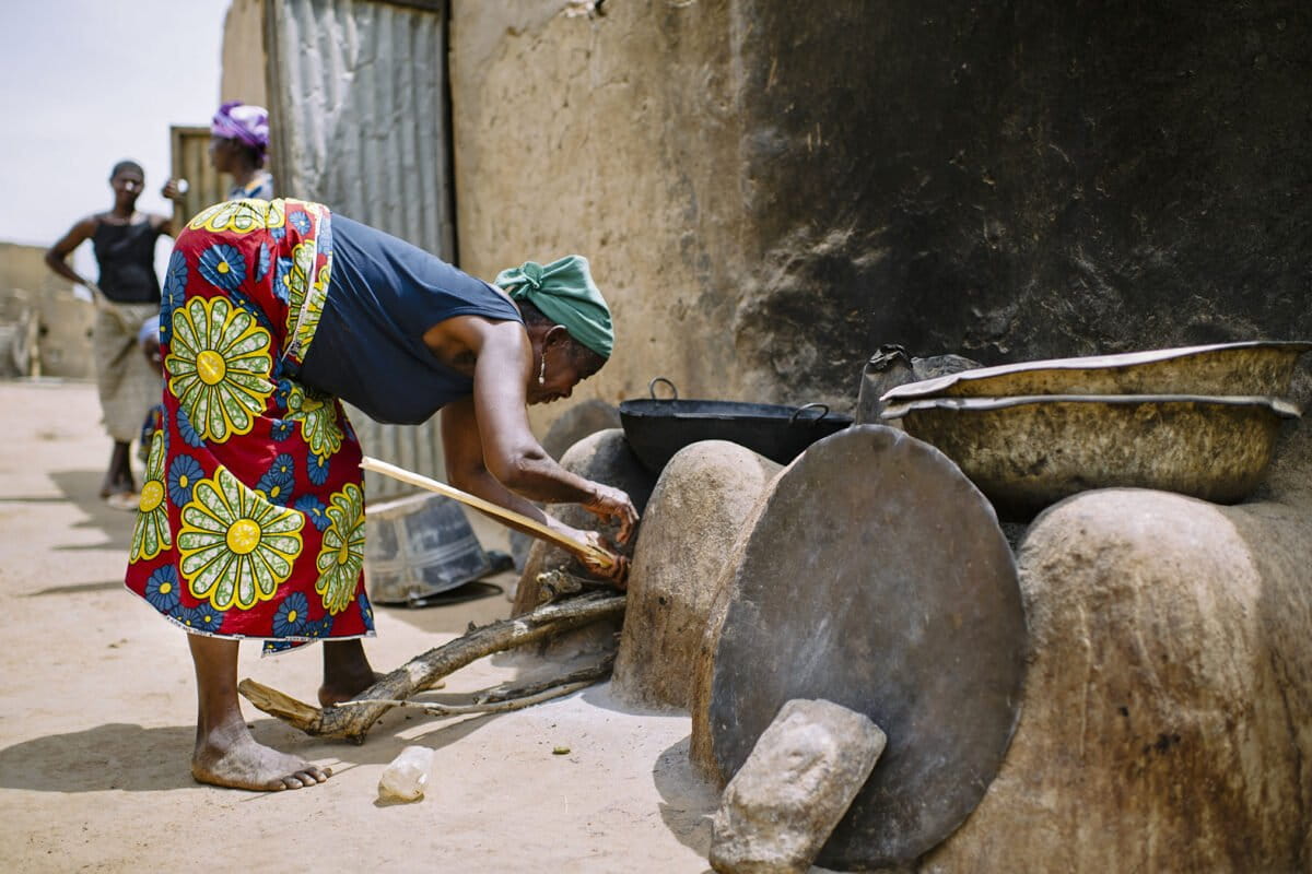 A woman lights her stove to prepare lunch, in the village of Zorro, Burkina Faso.