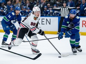 Chicago Blackhawks' Connor Bedard (98) and Vancouver Canucks' Filip Hronek (17) vie for the puck during the first period on Wednesday night at Rogers Arena.