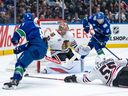 Chicago Blackhawks goaltender Spencer Knight (30) stops Vancouver Canucks' Conor Garland (8) as Elias Pettersson (40) watches and Blackhawks' Artyom Levshunov (55) defends during the third period at Rogers Arena on November 5, 2025.