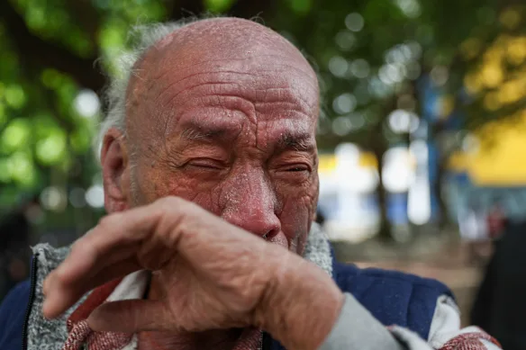 Resident Mr Si, 72, reacts to the devastation that has left him homeless.