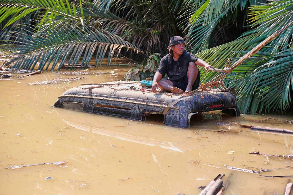 A man tries to retrieve a vehicle submerged in flood waters caused by Typhoon Kalmaegi in Liloan, Cebu province, central Philippines on Thursday, Nov.  6, 2025. (AP Photo/Jacqueline Hernandez)