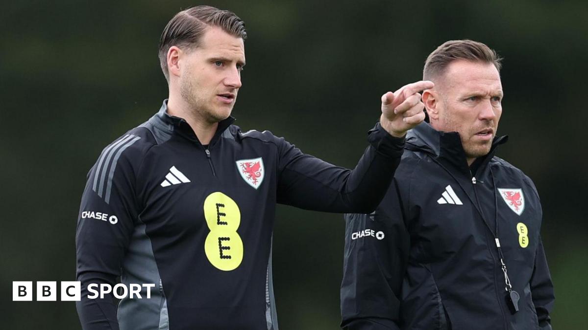 Piet Cremers (L) points with Craig Bellamy (R) next to him