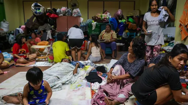 Affected residents take shelter inside a classroom, at a school that has been converted into an evacuation centre