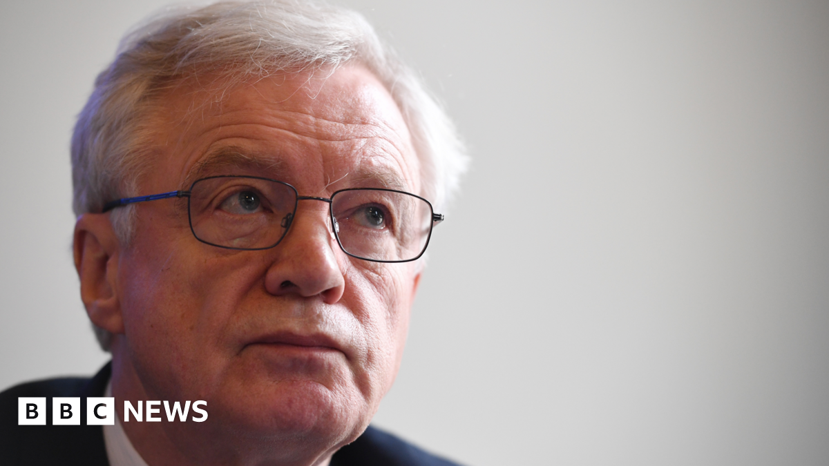 A close up of Sir David Davis. He's wearing glasses and a suit with a white shirt.