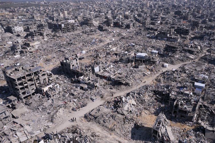 Aerial view of a city that has been largely destroyed and left in rubble, with hardly any intact buildings standing