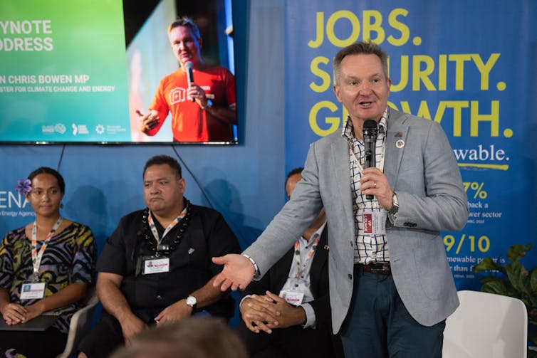man talking into microphone at panel.