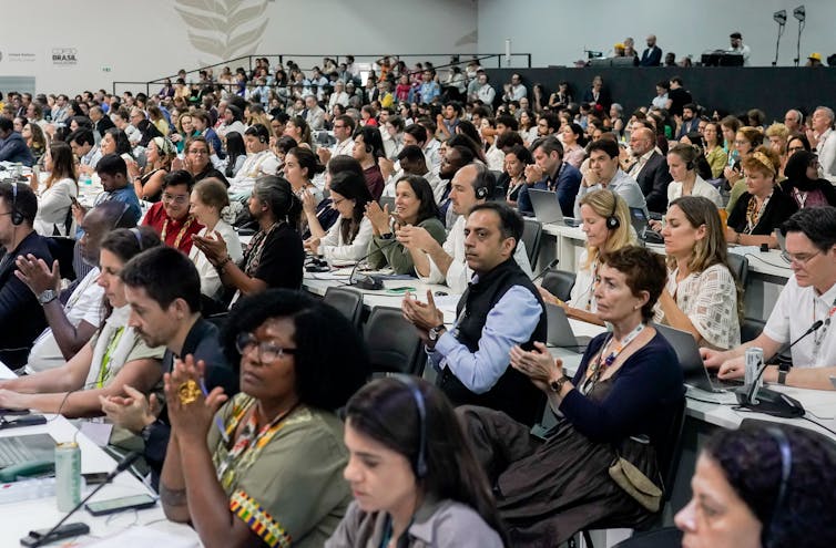 people sitting in room at climate talk conference.