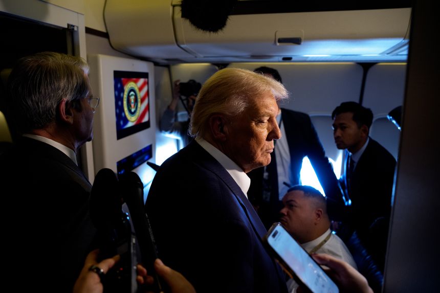 President Donald Trump, accompanied by U.S. Treasury Secretary Scott Bessent (L), speaks to members of the media aboard Air Force One on October 27, 2025, in flight.