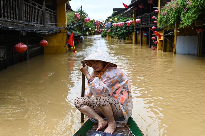 A woman rows a boat on a flooded street following heavy rains in Hoi An, Vietnam on October 30, 2025.