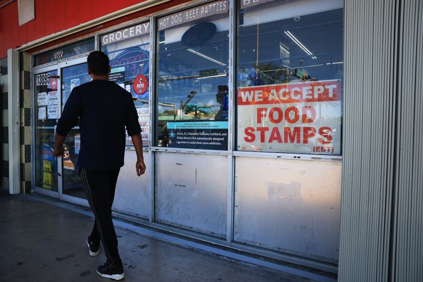A 'We Accept Food Stamps' sign hangs in the window of a grocery store on October 31, 2025 in Miami, Florida.