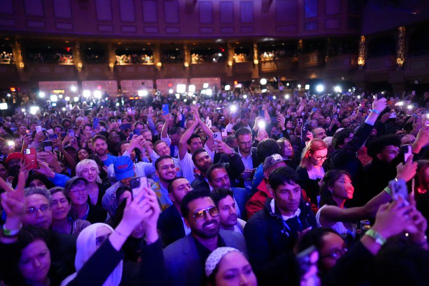 Attendees photograph the stage during Mamdani’s election night event.