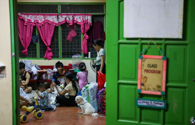 Affected residents including children take shelter inside a classroom at a school-turned shelter due to flooding caused by Typhoon Kalmaegi, in Cebu Province, Philippines on November 5, 2025.